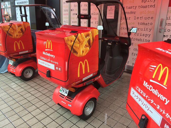 Interesting Japan pics: McDelivery scooters with red boxes featuring fries parked in a tiled area.