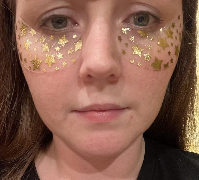 Close-up of a woman wearing gold star face patches under her eyes, showcasing things that work hard and look good.