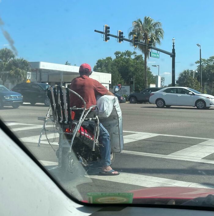 A man in red on a mobility scooter at a Florida intersection, capturing wild moments in traffic.