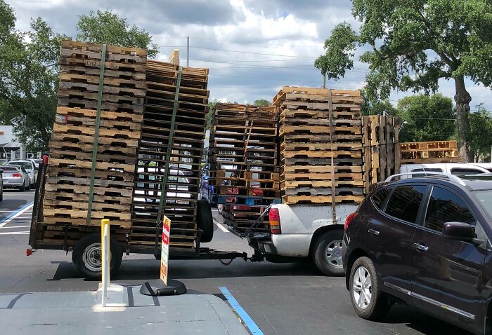Truck overloaded with wooden pallets in a Florida parking lot, capturing wild moments of daily life.