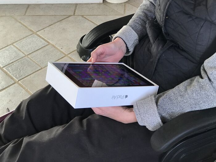 Person holding an iPad box like a screen, illustrating hilarious misunderstandings.