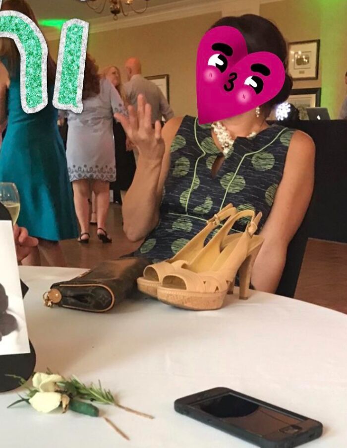 Guest at a wedding with high heels on the table, expressing frustration.