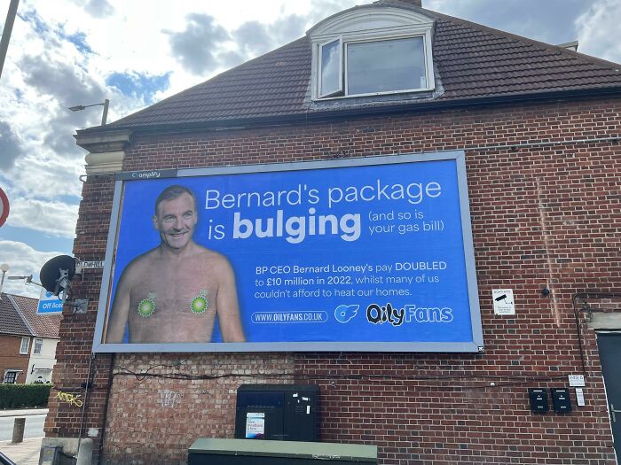 Funny billboards on a brick wall, featuring a humorous message about pay and gas bills.