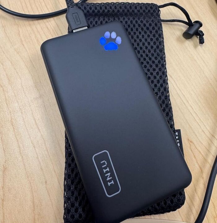 Portable charger on a wooden table, useful item to avoid common travel mistakes.