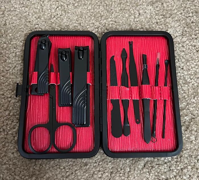 Travel items: a manicure set with clippers, scissors, and tools on a red background.