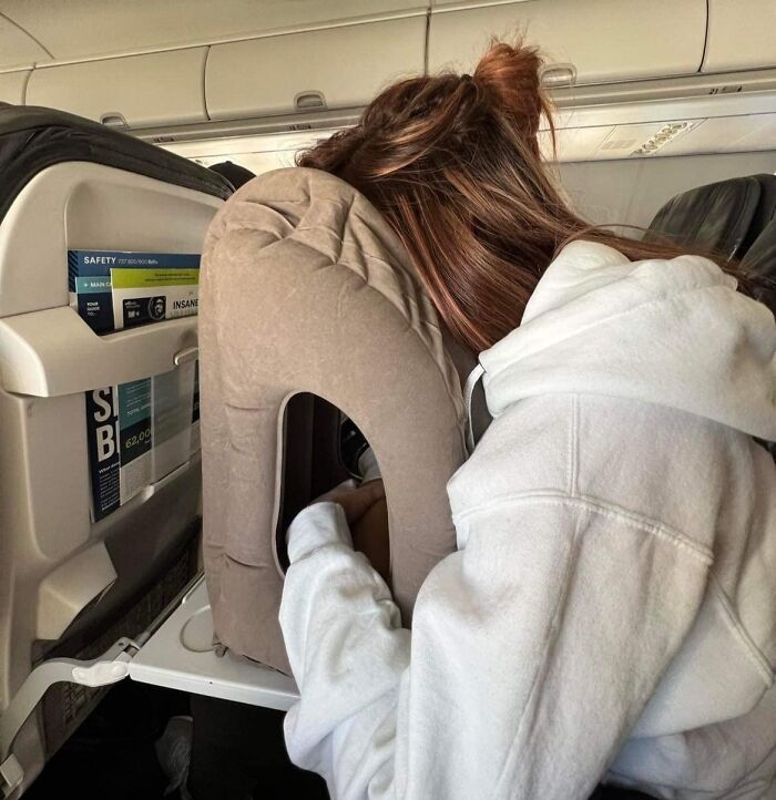 Person on a plane using a travel pillow to avoid common travel mistakes.