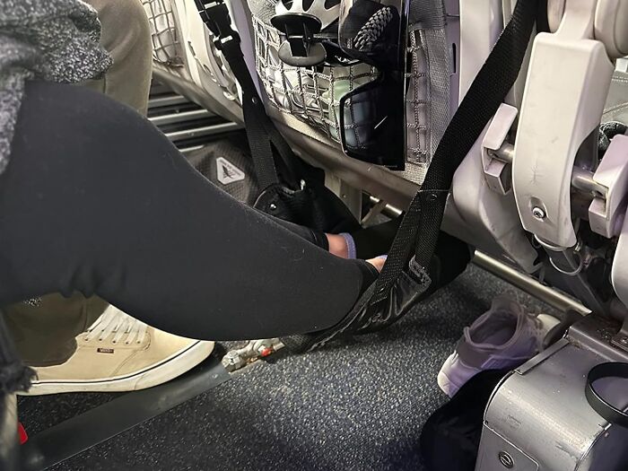 Airplane seat with leg hammock used to avoid common travel mistakes, showing comfort accessories.