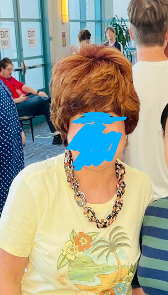 Person with a voluminous hairstyle in a crowded indoor setting, illustrating hair fail.