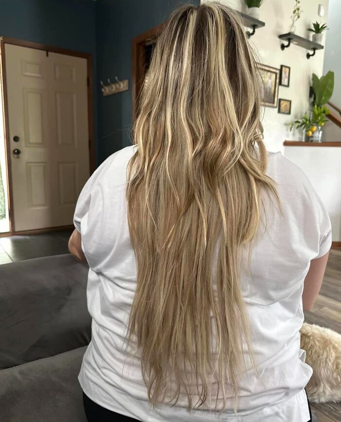Long, uneven hair with highlights, showcasing a hair fail from the back in a living room setting.