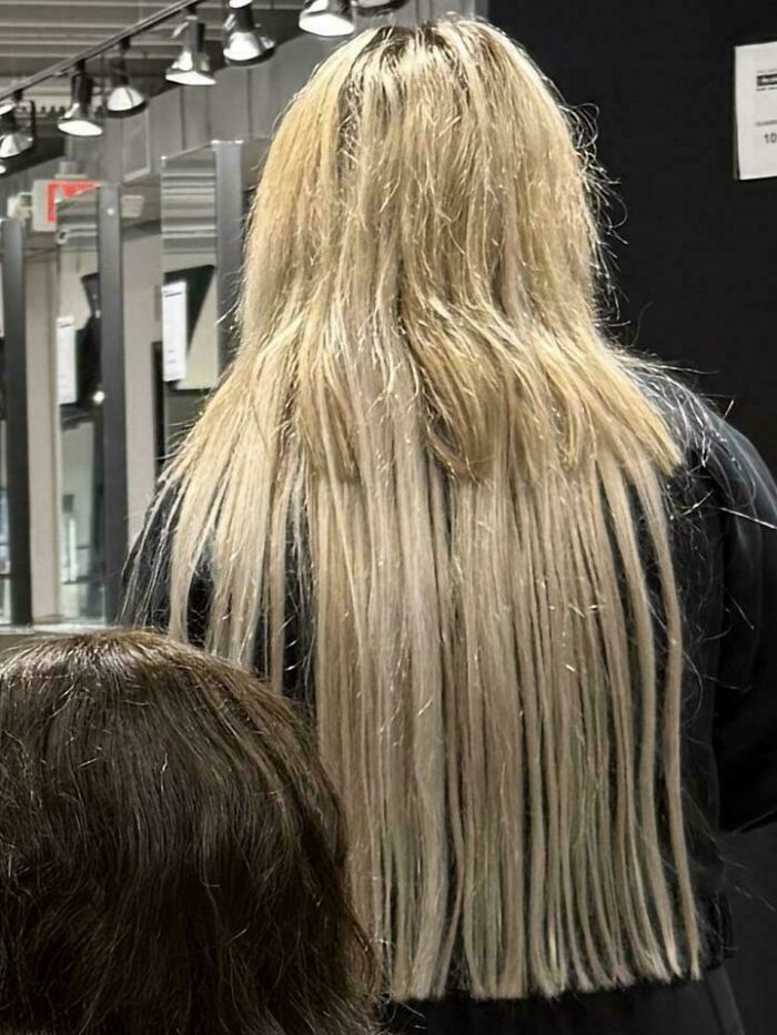 Woman with long blonde hair, an unfortunate haircut, demonstrating severely layered and uneven lengths.