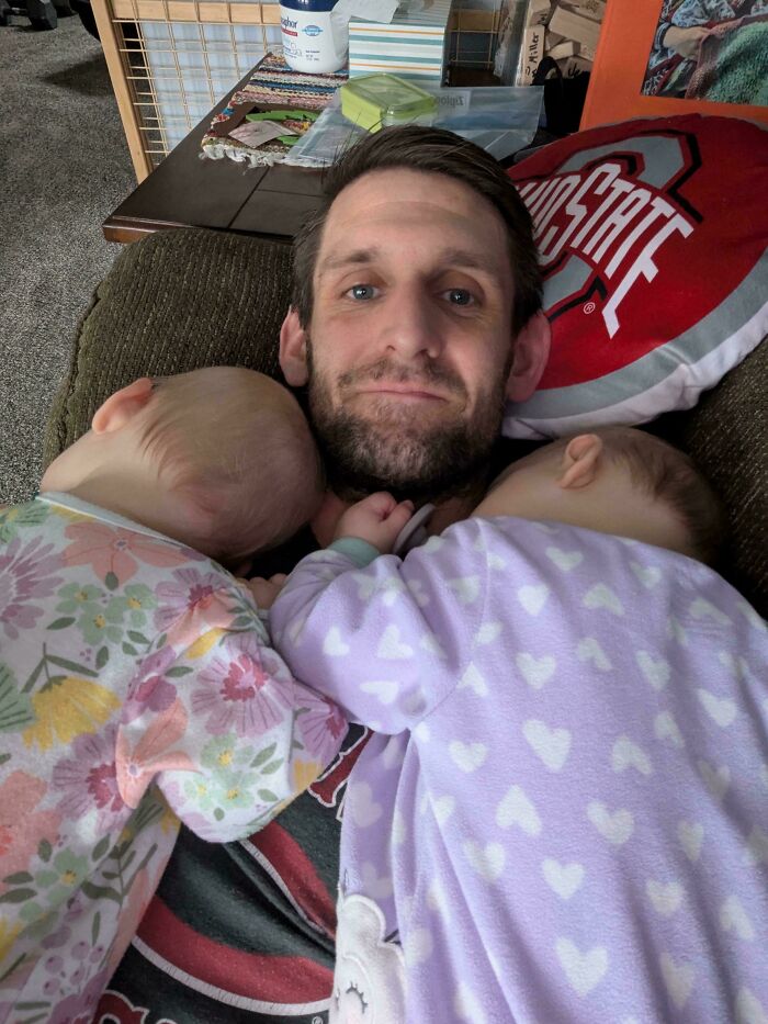 Dad cuddling two sleeping babies on his chest, showing heartfelt parenting moments and tender fatherly care at home.