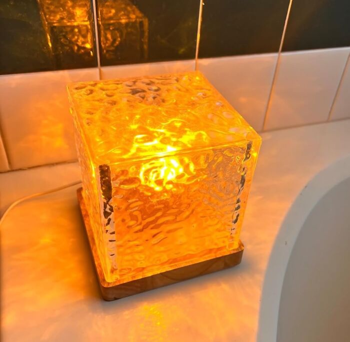 Glowing amber glass lamp, popular cult favorite decor item illuminating a bathroom setting.