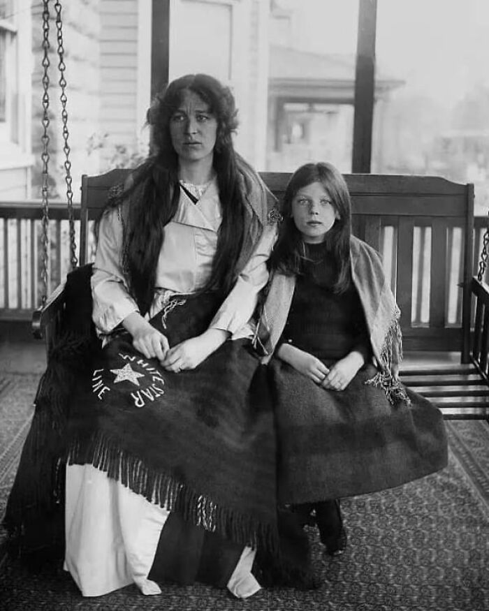 Two women sitting on a porch swing with blankets, representing an interesting historical fact.