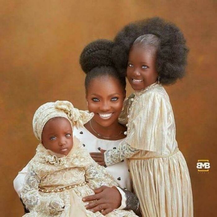 Smiling mother with two children in elegant outfits, highlighting interesting family moments.