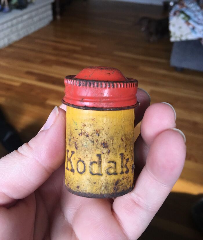 Hand holding a vintage Kodak film canister, showcasing a piece of cool old things.