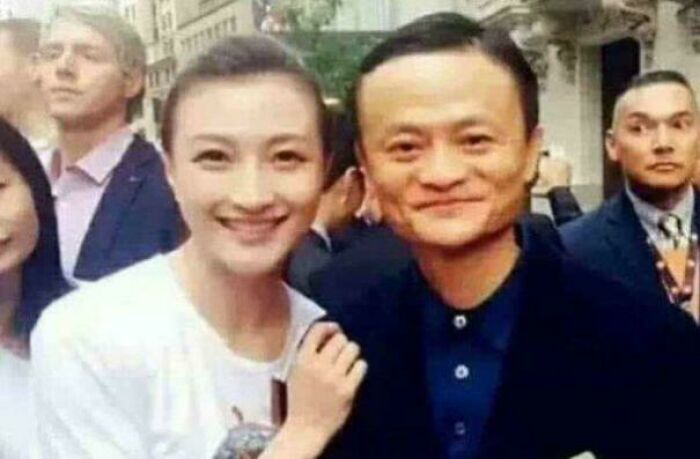 A woman and a man smiling at an outdoor event, surrounded by other people, relating to interesting facts.