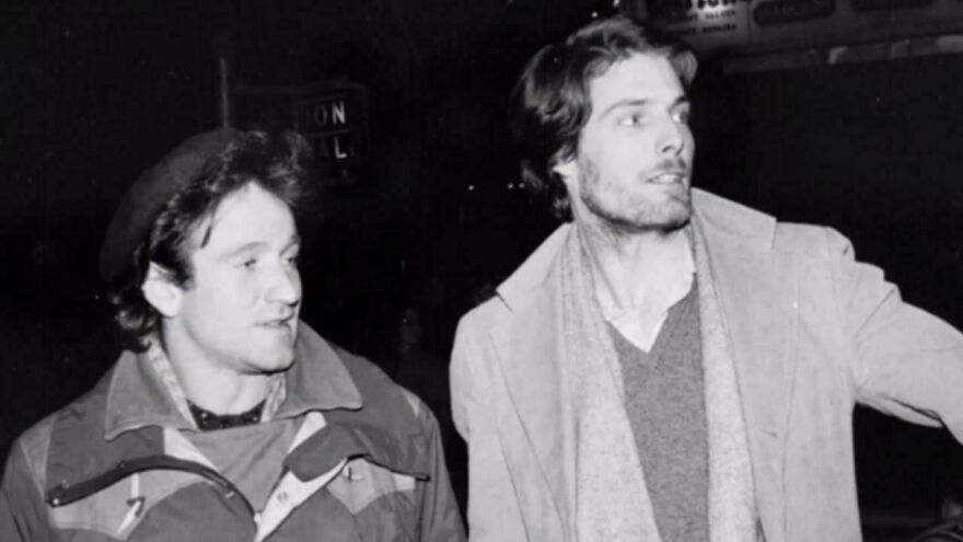 Two men in a historical photo walking at night, wearing winter clothing, engaged in conversation.