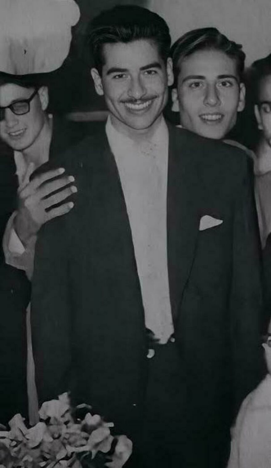 Group of men in vintage suits smiling at a historical event.