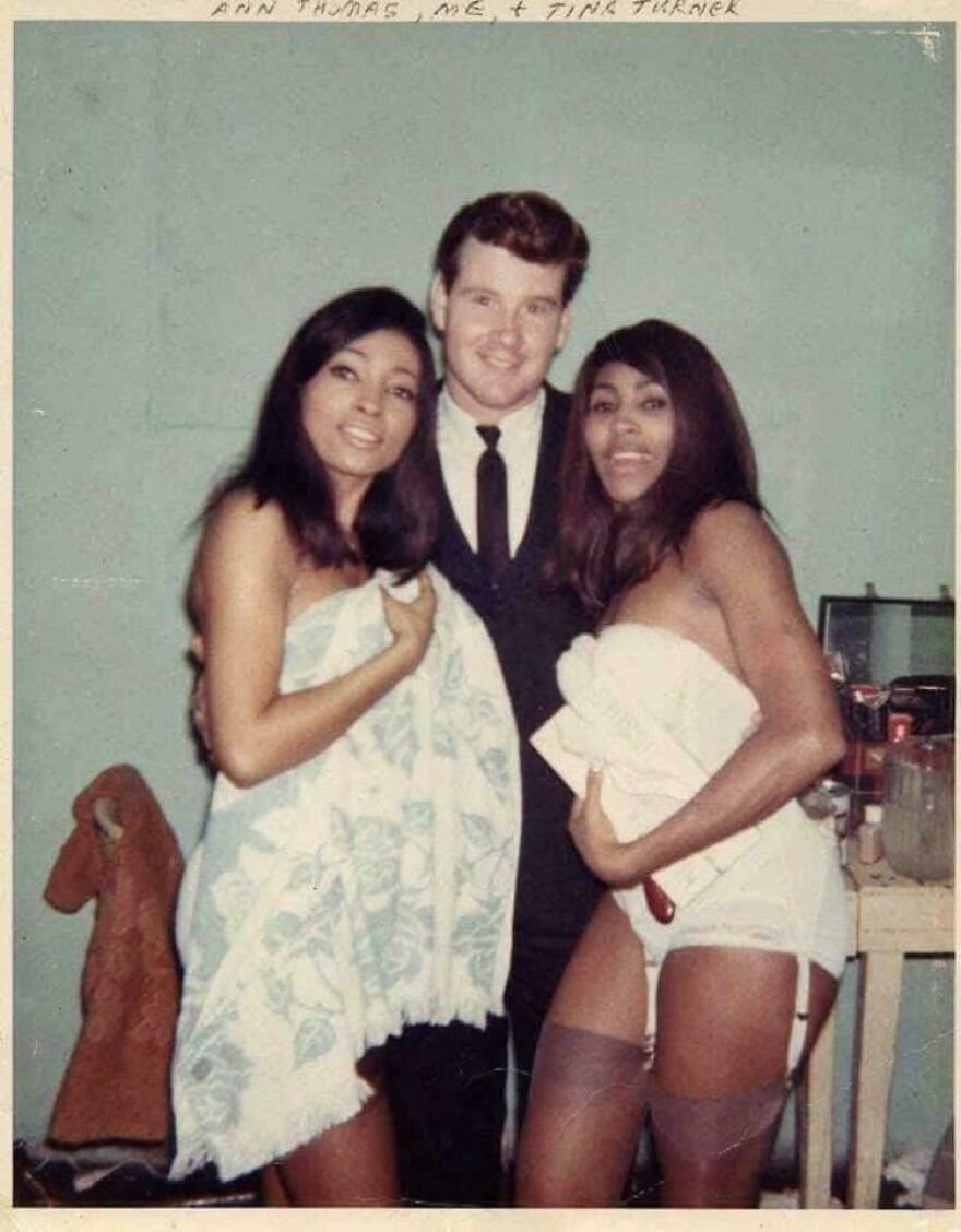 Two women in towels and a man in a suit posing together, reflecting historical moments from the past.