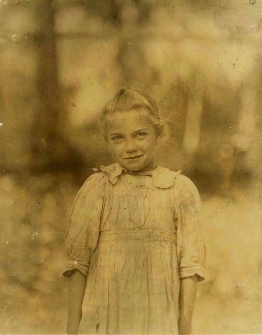Young girl in vintage clothing, smiling softly, representing unseen historical photos in sepia tones.