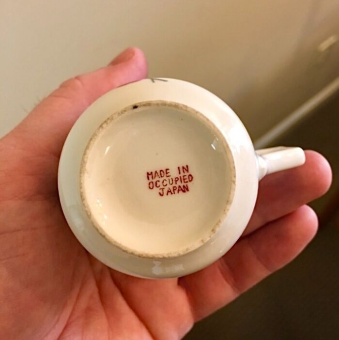 Person holding vintage cup with "Made in Occupied Japan" marking, a classic example of cool-old-things.