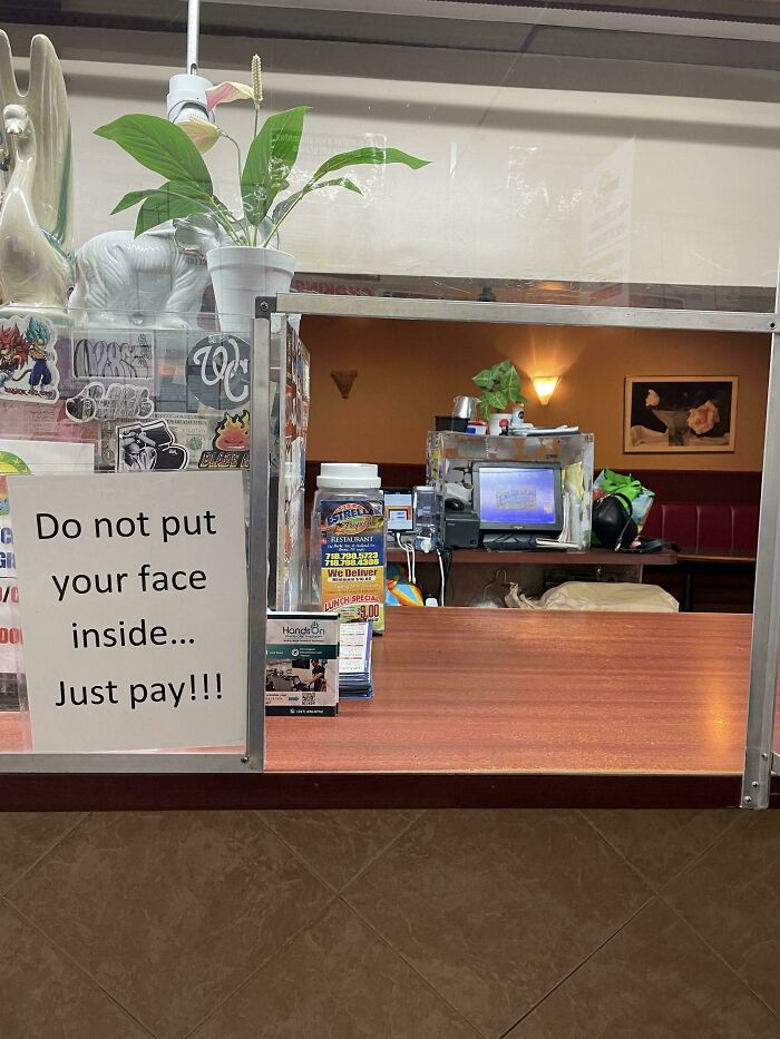 Funny sign at a counter says, "Do not put your face inside... Just pay!!!"