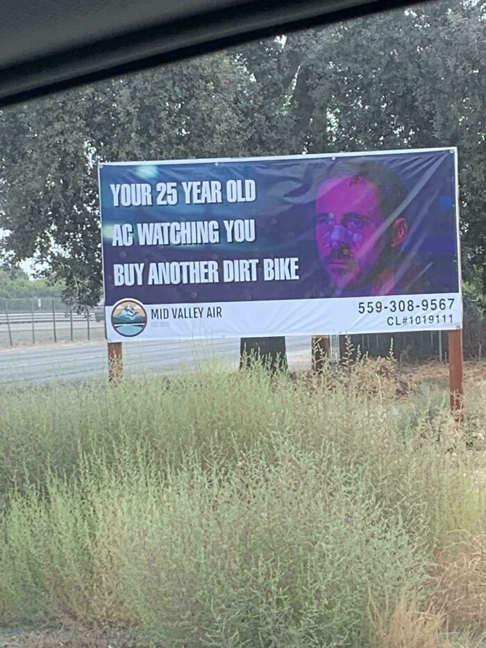Funny signs billboard with a humorous message about buying another dirt bike.