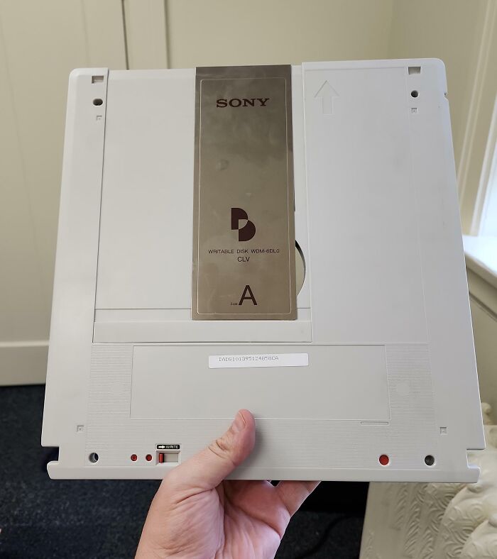 Hand holding a vintage Sony writable disk, showcasing cool-old-things technology.