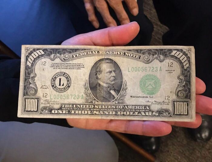 Hand holding a vintage one thousand dollar bill, showcasing cool old things.