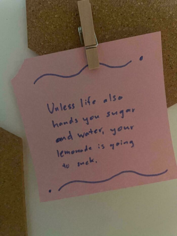 Humorous sign on pink paper clipped to a corkboard, featuring a witty lemonade quote.