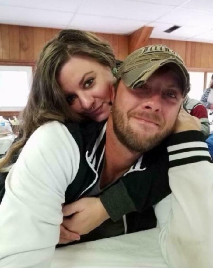 Couple embracing in a cozy room, one wearing a cap, evoking a serene moment despite terrifying backstories linked to photographs.