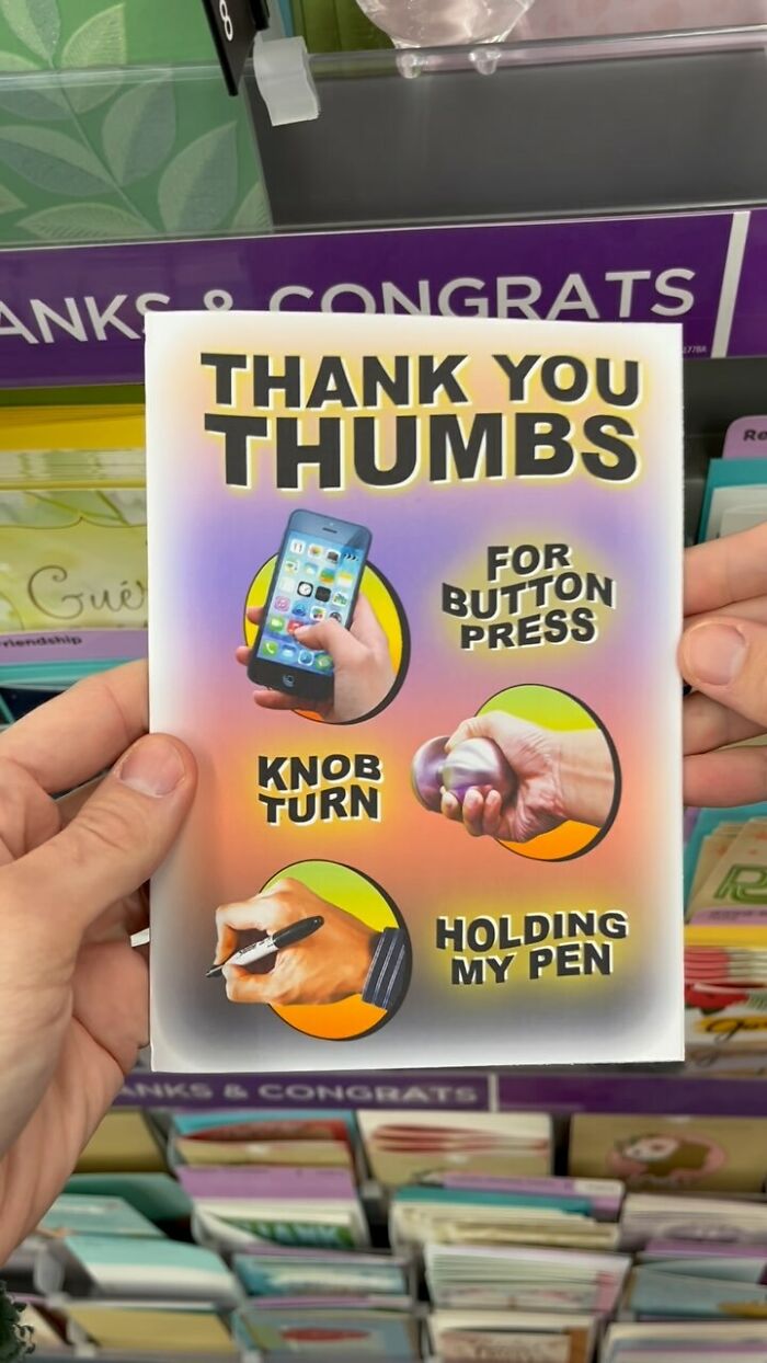 Person holding a funny fake product card showing thumbs used for button press, k**b turn, and holding a pen in a store.