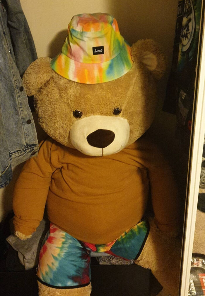 Giant teddy bear wearing a colorful tie-dye hat, perfect Valentine's gift inspiration for a cute and fun occasion.