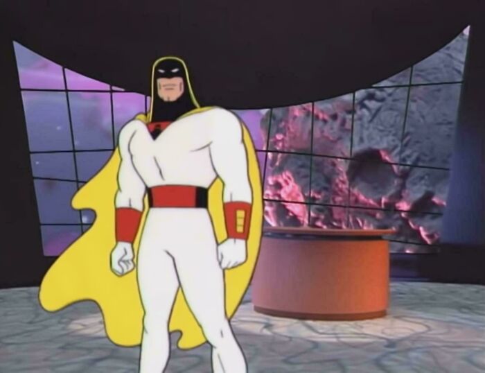 Animated character in a superhero costume with a yellow cape, standing in a '90s-style futuristic setting.