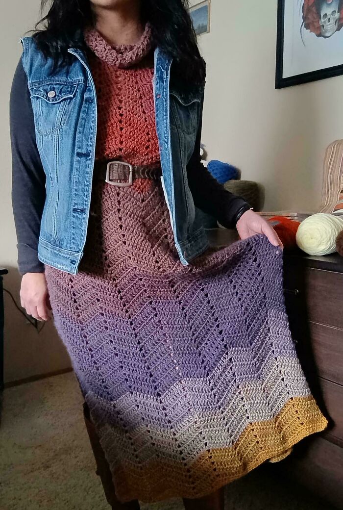 Woman showcasing a handmade crochet dress with gradient colors, highlighting beautiful crochet masterpieces and intricate stitch patterns.