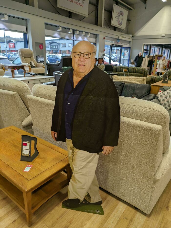 Cardboard cutout found while thrifting in a store, amongst sofas and chairs, offering a unique discovery experience.