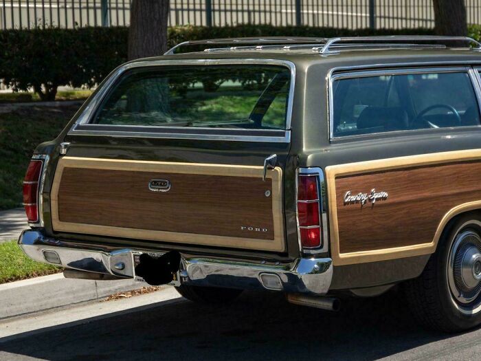 Vintage Ford station wagon with wood paneling, parked on a sunny street, evokes nostalgia and makes you feel old.