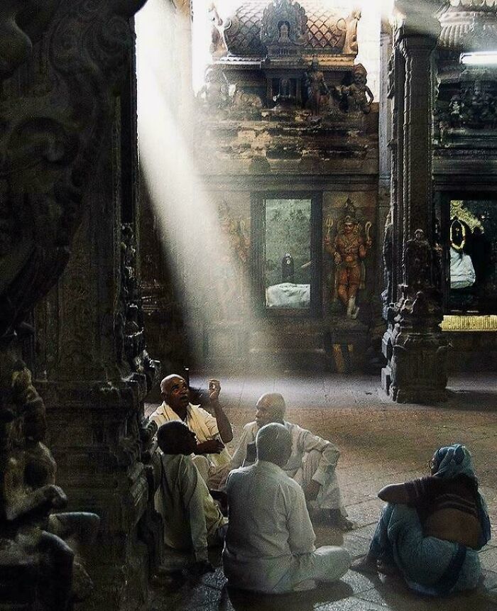 People sitting in a temple's dramatic light, resembling an accidental Renaissance painting.