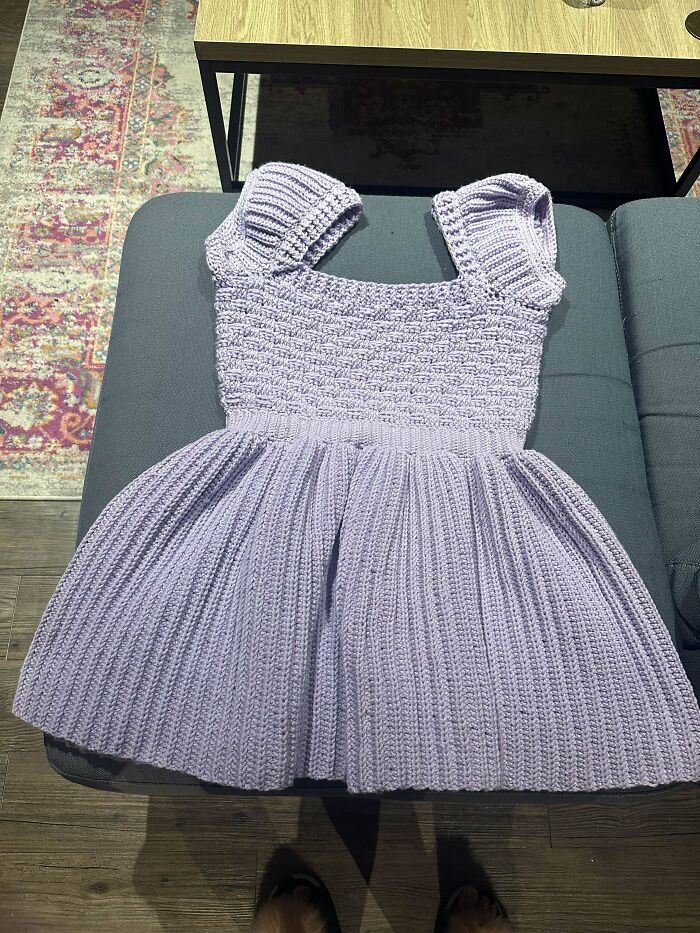 Light purple crocheted dress with puff sleeves and textured skirt, showcasing detailed crochet masterpieces and craftsmanship.