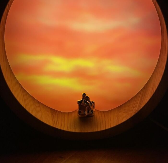 Couple figurines cuddling in front of a sunset, symbolizing V-Day for long term relationships.