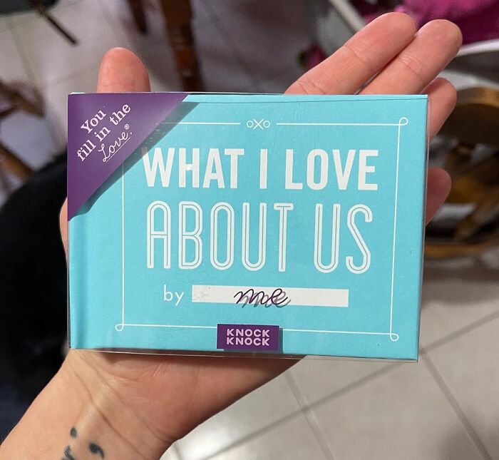 Person holding a book titled "What I Love About Us," ideal for long-term couples.