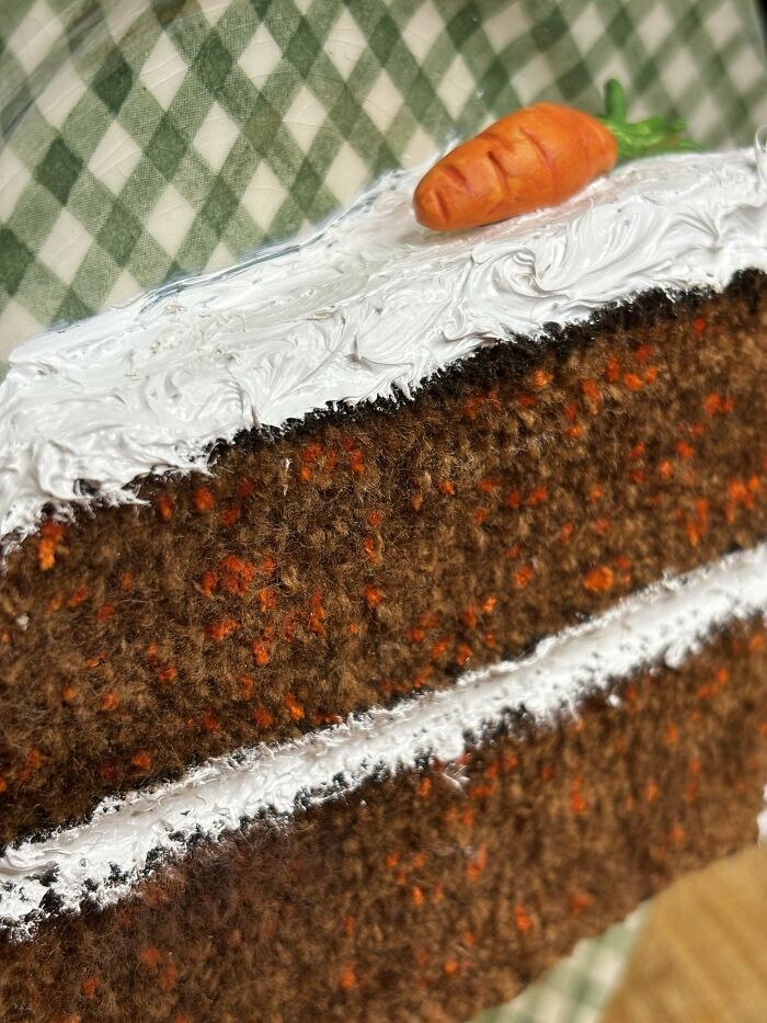 DIY project of a knitted carrot cake slice with frosting and an orange carrot on top.
