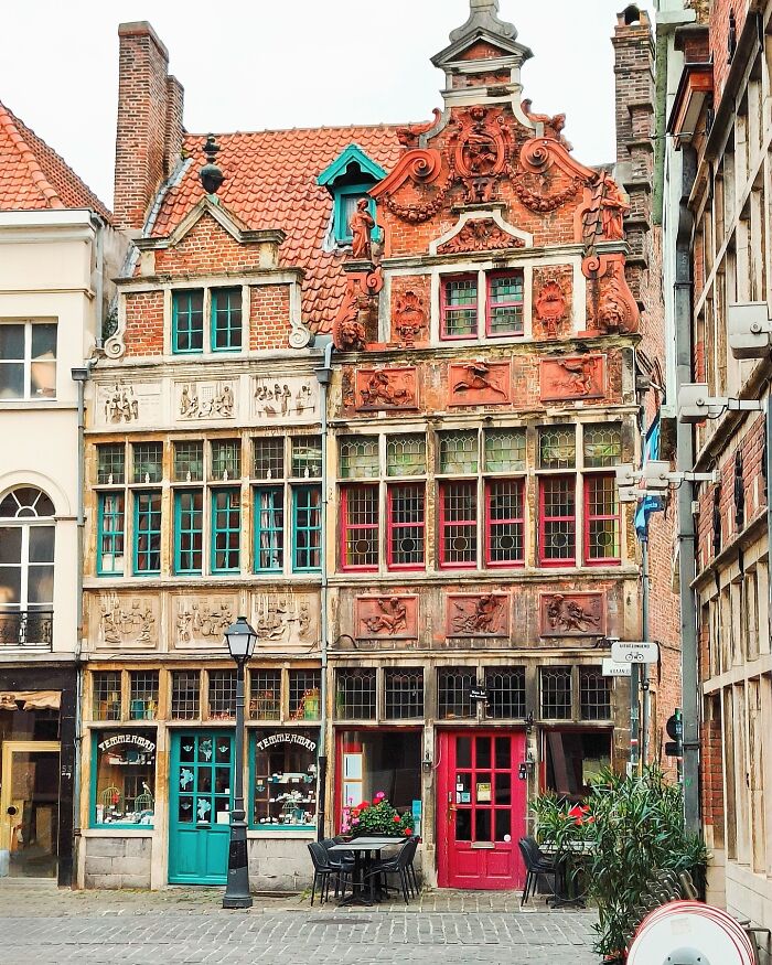 Historic European buildings showcasing impressive architectural feats with intricate facades and vibrant windows on a cobblestone street.