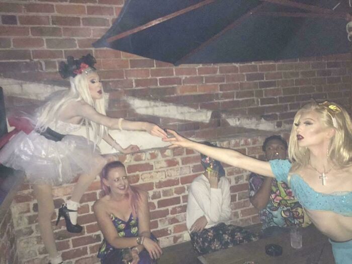 Two people reaching out to each other dramatically, resembling an accidental renaissance painting.