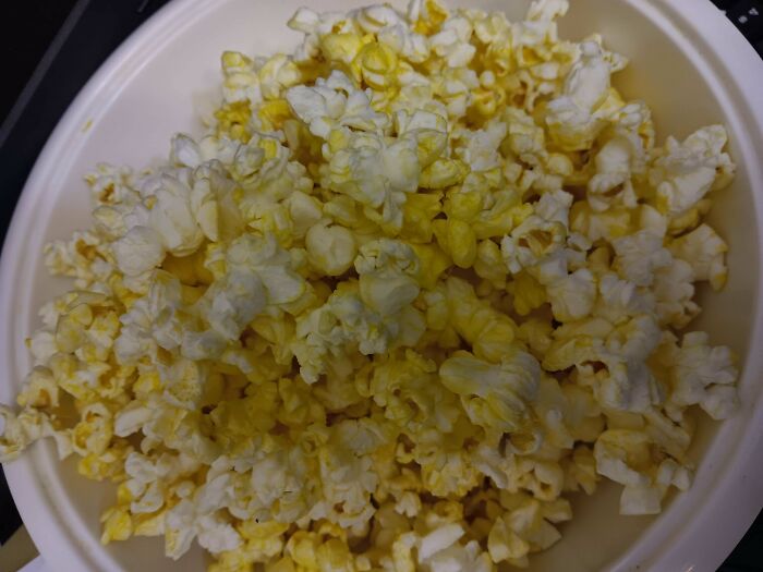 Close-up of popcorn kernels in a bowl, showcasing a rare coincidence in shape and color captured perfectly in a photo.