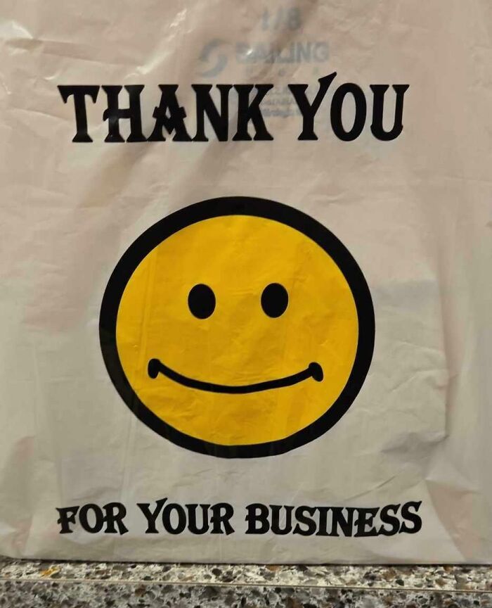 Smiley face on a "Thank You For Your Business" bag on a countertop for mild amusement.