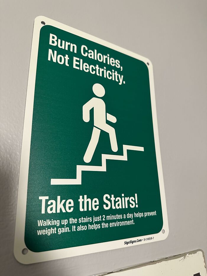Funny sign encouraging stair use over electricity for calorie burning.