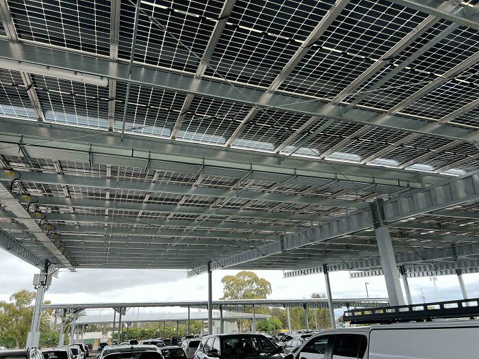 Solar panels installed over a parking lot, showcasing Cities-Genius-Solutions for clean energy in urban areas.