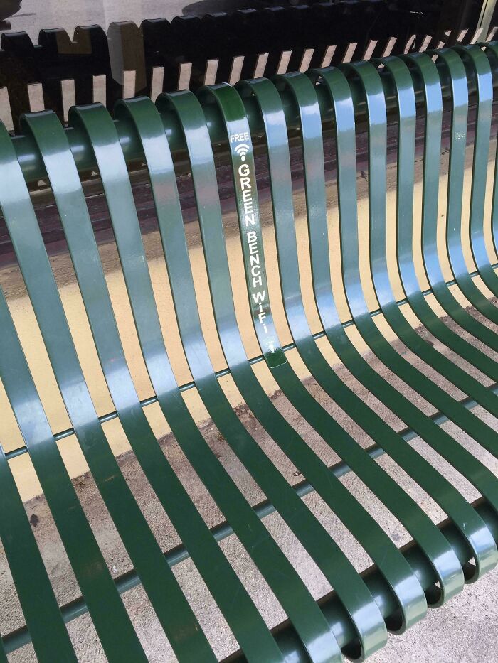 Green bench offering free Wi-Fi, showcasing Cities-Genius-Solutions for public connectivity.