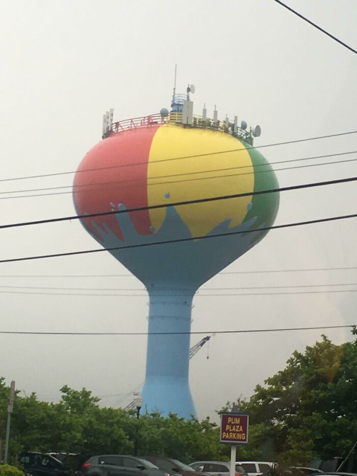 Colorful water tower resembling a beach ball representing Cities-Genius-Solutions innovation against a cloudy sky.